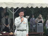 作業服姿の市長がテントの前でマイクを持ち立っている写真