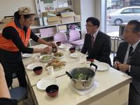 市長に女性が食べ物をよそっている様子の写真