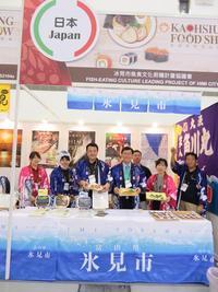 高雄国際食品展覧会にて高雄市役所の方々と一緒に氷見市と書かれたスペースで販売する市長の写真