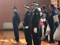 防災訓練用の制服を着た男性達が後列の人は白い袋を持っている写真