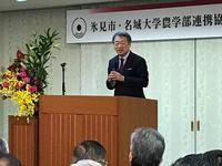 池上彰先生が花が飾られた壇上で講演をしている写真