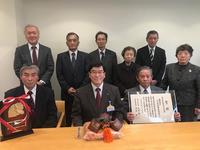 富山県農村文化賞の賞状と楯を持ったメンバーたちと市長の集合写真