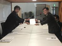 連合富山・高岡地域協議会氷見地区協議会員の男性と市長が二人一緒に要望書を持っている写真