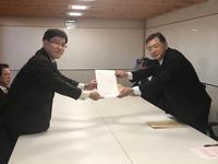 富山県建設技術協会員の男性と市長が二人一緒に要望書を持っている写真