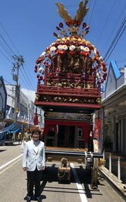 祇園祭りの大きな山車の前に立つ市長の写真
