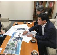 小松製作所さんでテーブルに写真を広げ造成の状況の説明する市長の写真
