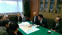 国土交通省幹部へ市長ら数名がテーブルに地図などを広げ要望をしている写真