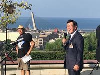 朝日山公園での背景を背に笑顔で挨拶する市長の写真