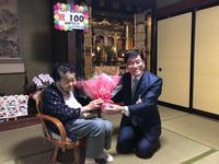 市長が満百歳の方のお宅へ伺い仏間で中村様へお祝いの花束を渡している写真