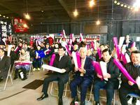 漁業文化交流センターでの箱根駅伝パブリックビューイングにて観客と共に赤と白の2本のバルーンを手に応援する市長の写真