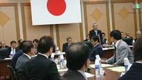 日本の旗を壁に掲げている市長会理事会の会場で関係者が着席している写真