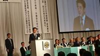 市長が出席した全国市長会通常総会にて安倍内閣総理大臣が演壇で祝辞をのべスクリーンに写っている写真