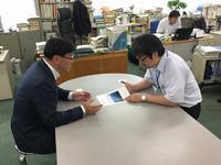 農林水産省の男性の担当課長に日本農業遺産の説明をする氷見市担当者の男性の写真
