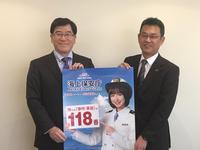 市長が海上保安部長と大きな赤い文字で118番と書かれたポスターを持つ写真