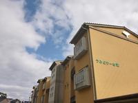 茶色い壁の2階建ての栄町特定公共賃貸住宅（うみどりーむ栄）の写真