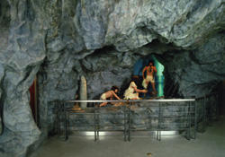 洞窟内を模した空間で男女と子供一人の人形が展示されている大境洞窟ジオラマの写真