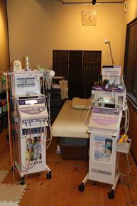 治療室にベットと2台の治療器具が置かれた写真